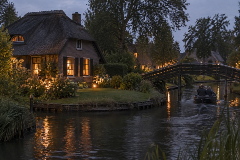 A thatched farmhouse on its own small island beside a narrow reed-lined canal, an arched wooden footbridge and a low whisper boat drifting past, Giethoorn, Netherlands