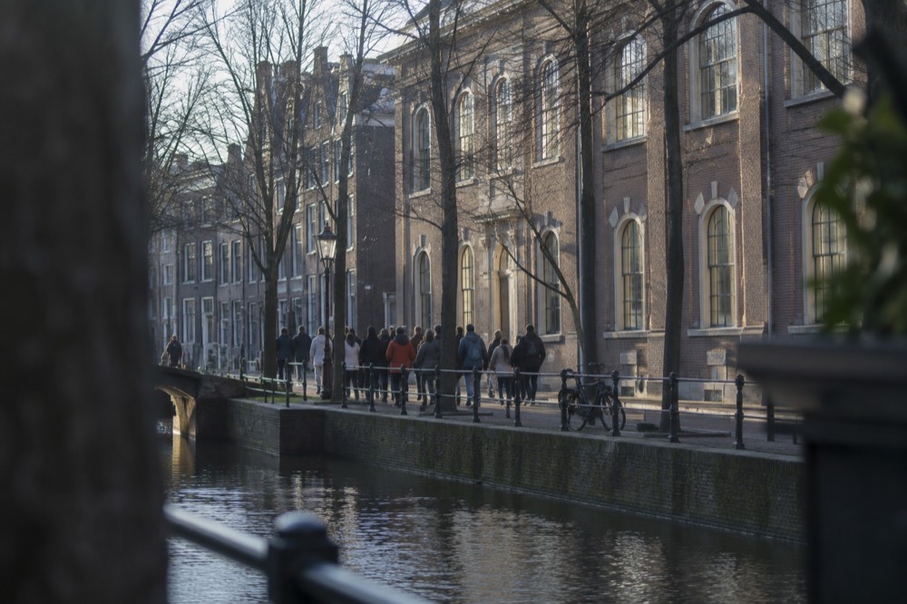 A tour group walking beside a canal in the old Jewish Quarter of Amsterdam