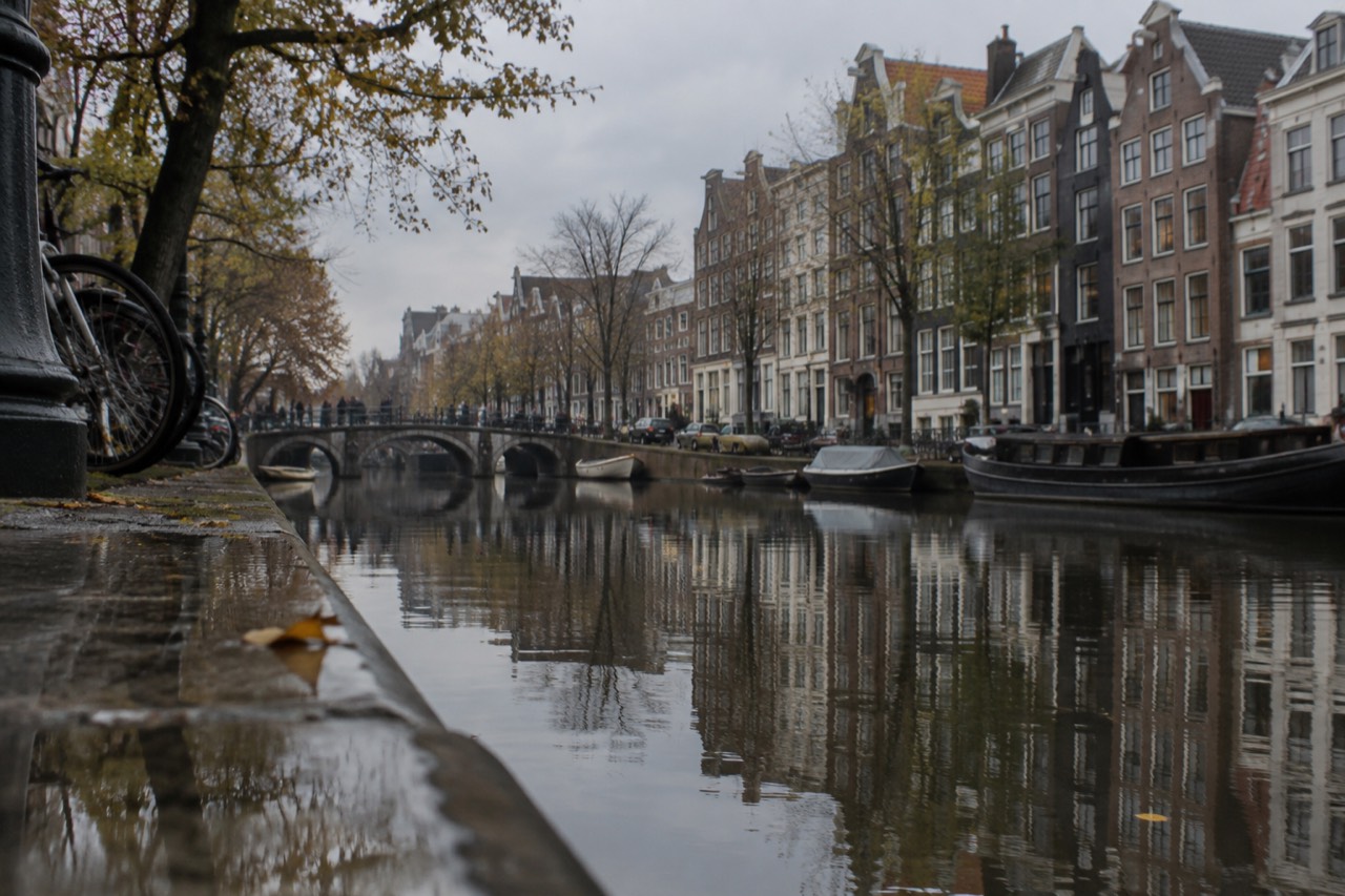Canal houses along an Amsterdam gracht reflected in still morning water