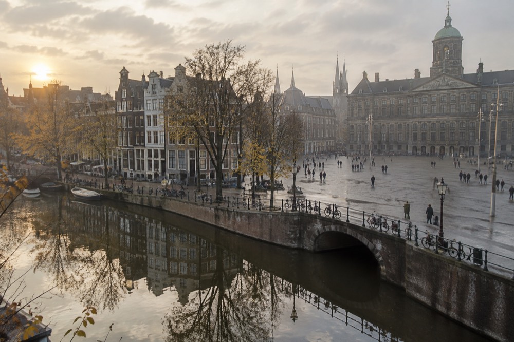 Amsterdam canal houses reflected in still water on a grey autumn morning