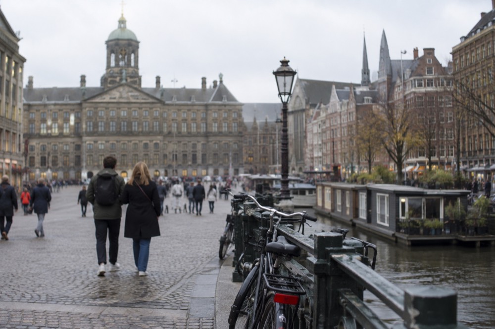 People walking past Dam Square, seen from across the street