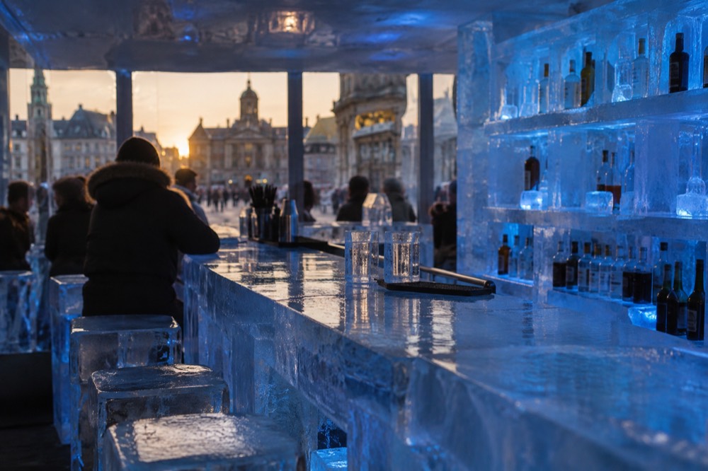 Bar counter and shelves made from blocks of clear ice lit in blue inside a freezing bar