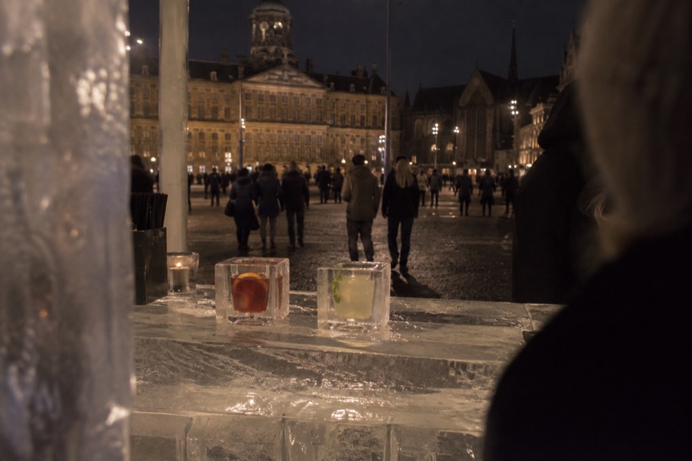 Two drinks in glasses carved from ice resting on a bar counter made of ice blocks
