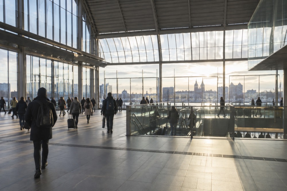 The modern interior hall of Amsterdam Centraal station with travellers passing through