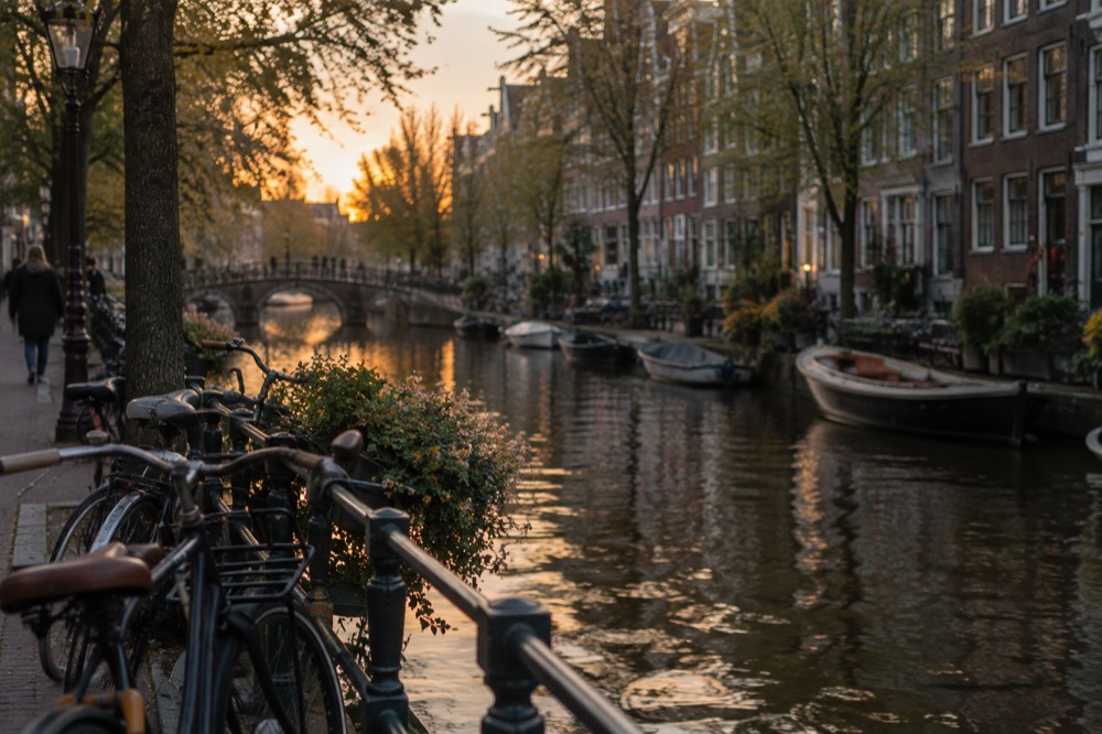 Bicycles and boats along a canal in the Jordaan neighbourhood at dusk