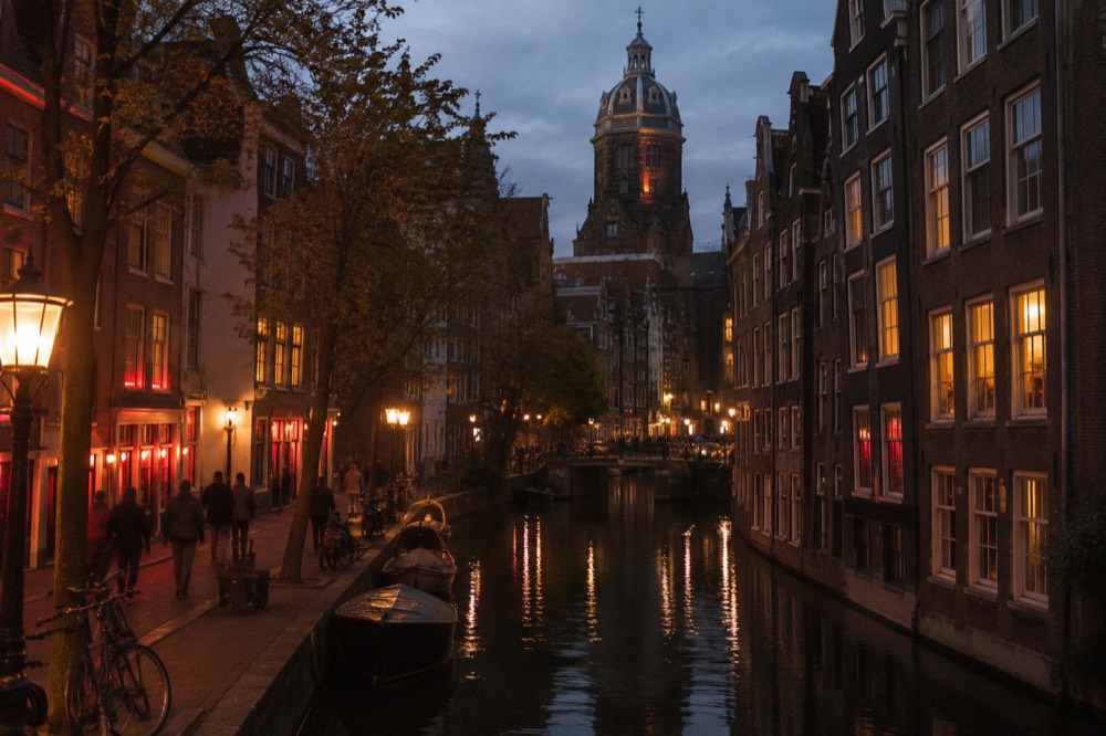 Old church tower rising above narrow Amsterdam streets in morning light
