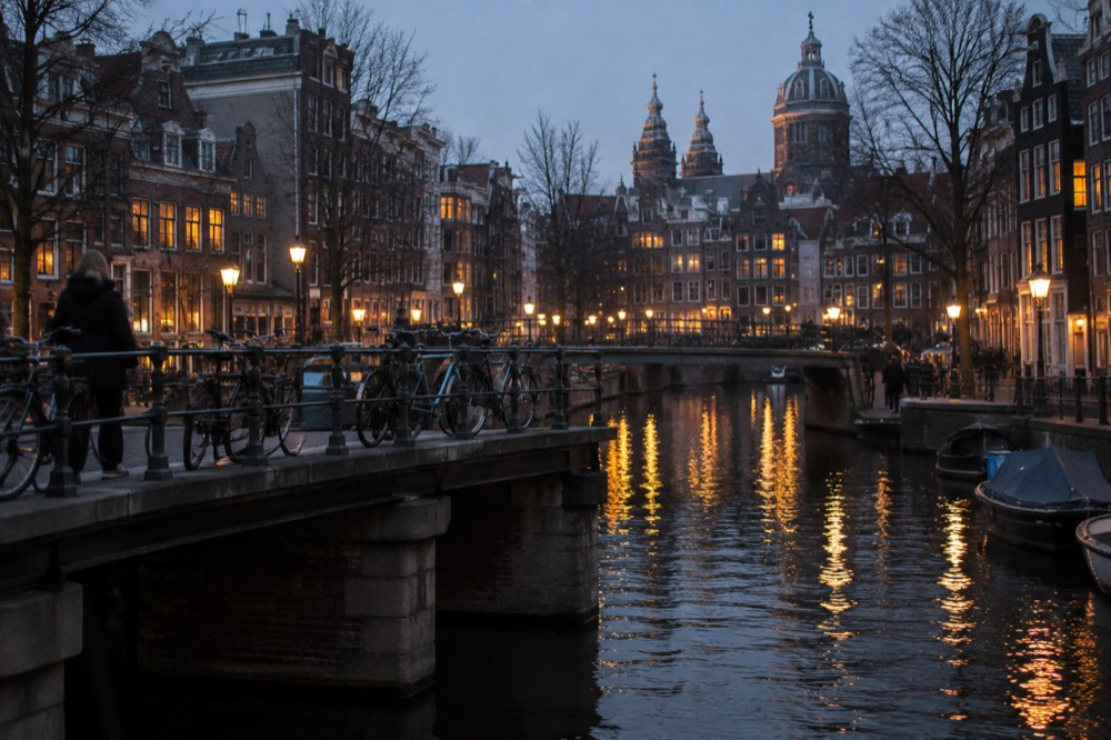 A canal bridge in central Amsterdam lined with bicycles and old brick buildings