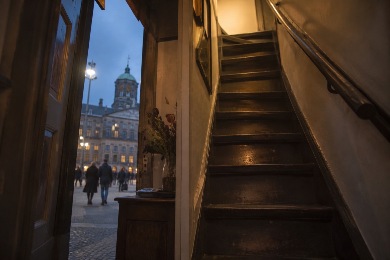 A steep narrow wooden staircase inside an old Amsterdam canal house