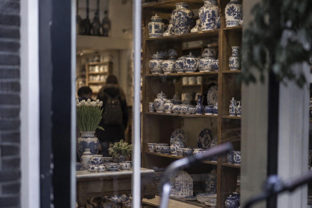 A display shelf of blue and white Delft-style ceramics in an Amsterdam shop