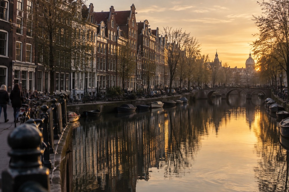 Amsterdam canal houses reflected in still water along the Grachtengordel at dusk