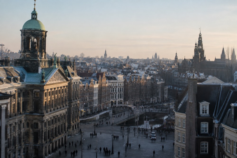 A winter view over Amsterdam rooftops with the skyline in cold morning light