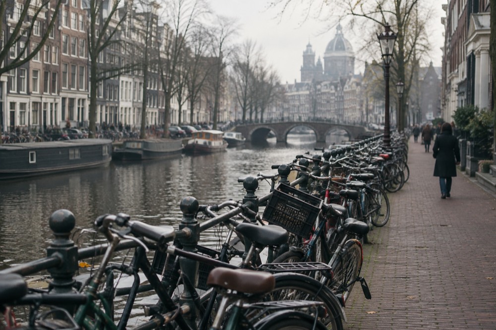 Bicycles parked in rows along a canal in central Amsterdam