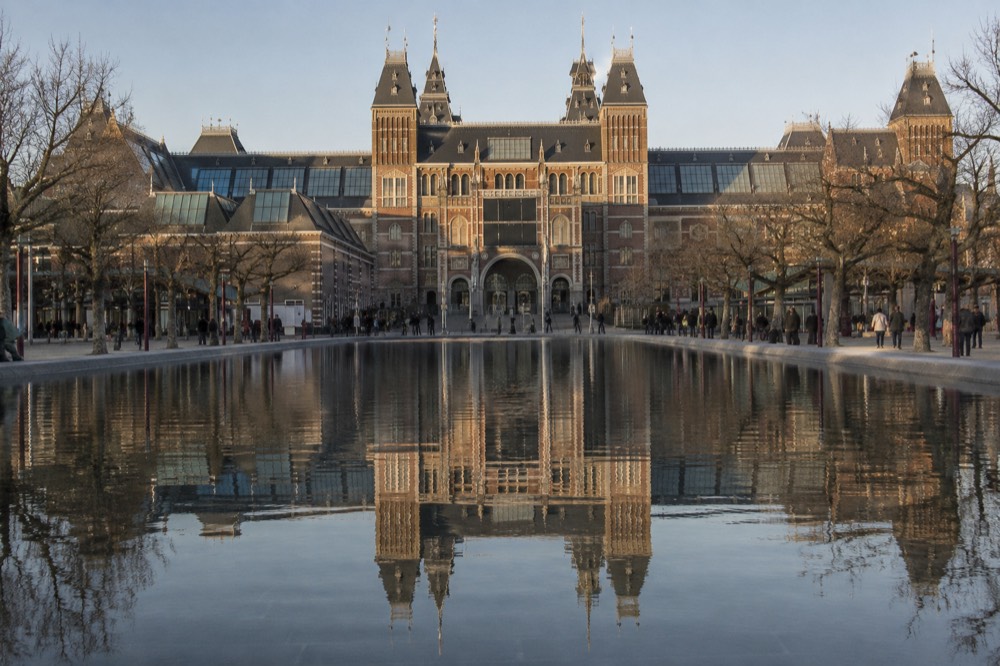 The Rijksmuseum facade reflected in the Museumplein pool