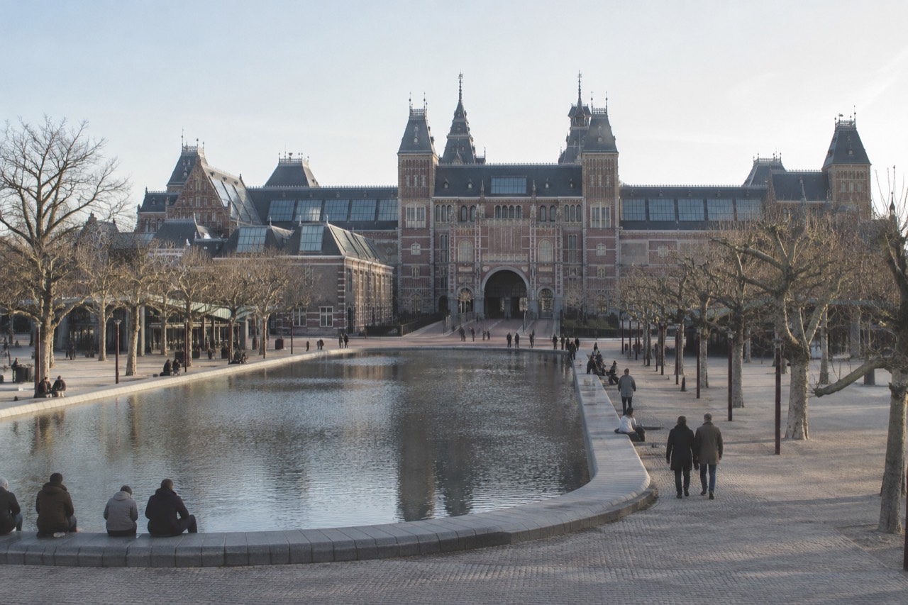 The Rijksmuseum building beside the Museumplein water feature on a bright day