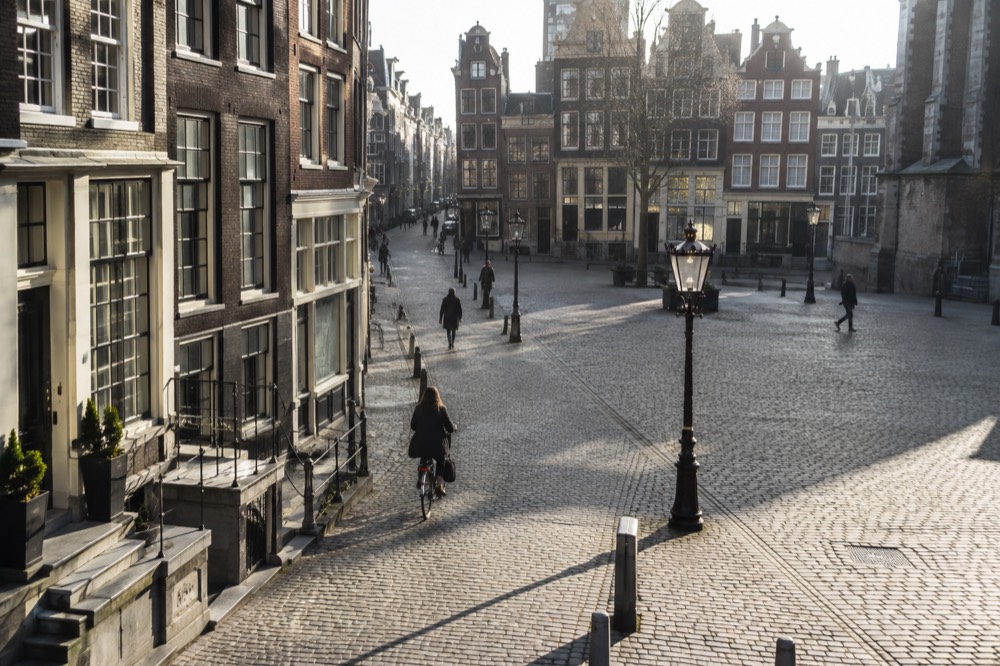 Morning light on a quiet street of tall narrow houses in central Amsterdam