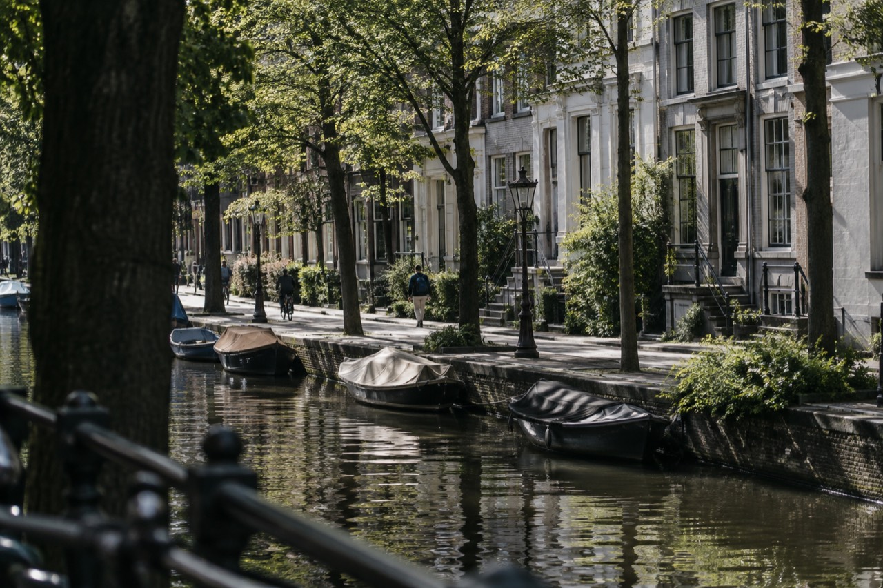 Tree-lined path beside a canal in the Plantage district with 19th-century facades