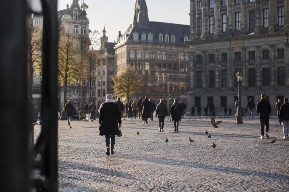 A quiet corner of Dam Square with trees overhanging the water