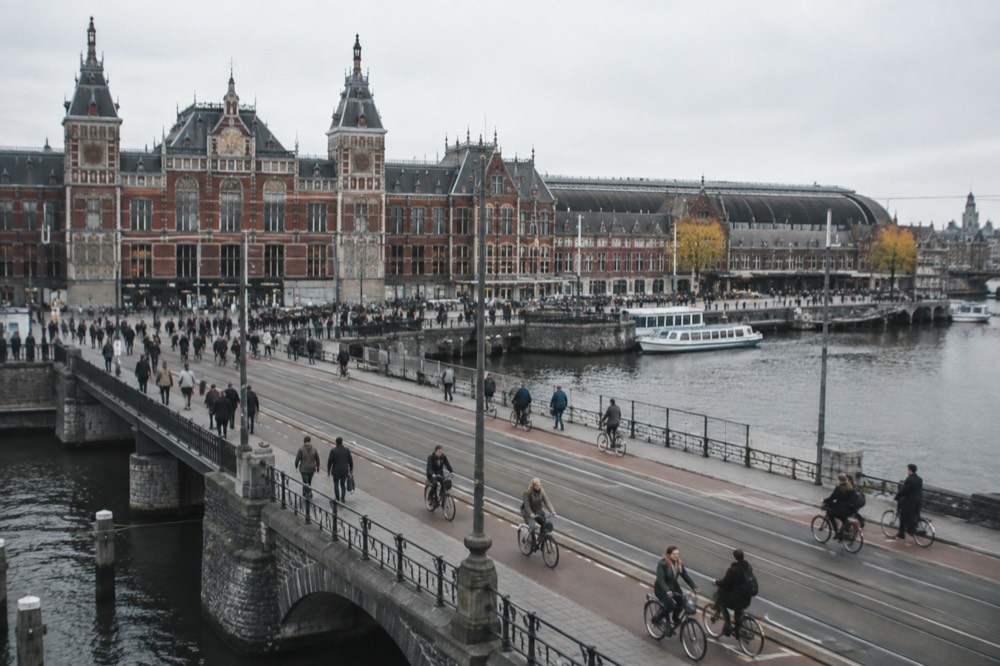 Bicycles and pedestrians crossing the bridge in front of the station toward the canal district