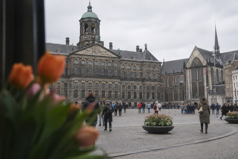 Brick facades and a quiet canal edge beside Dam Square