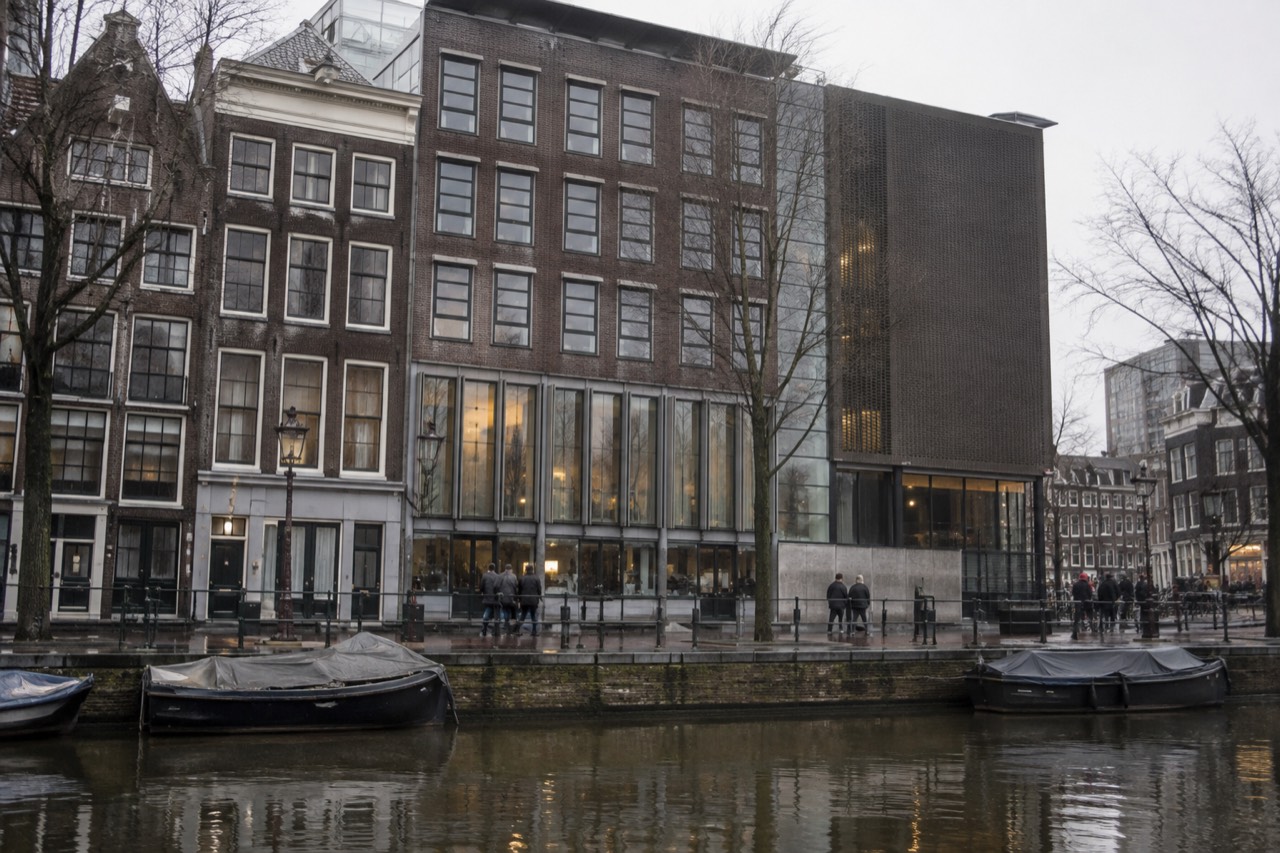 Exterior of the Anne Frank House museum in Amsterdam with the canal in front.