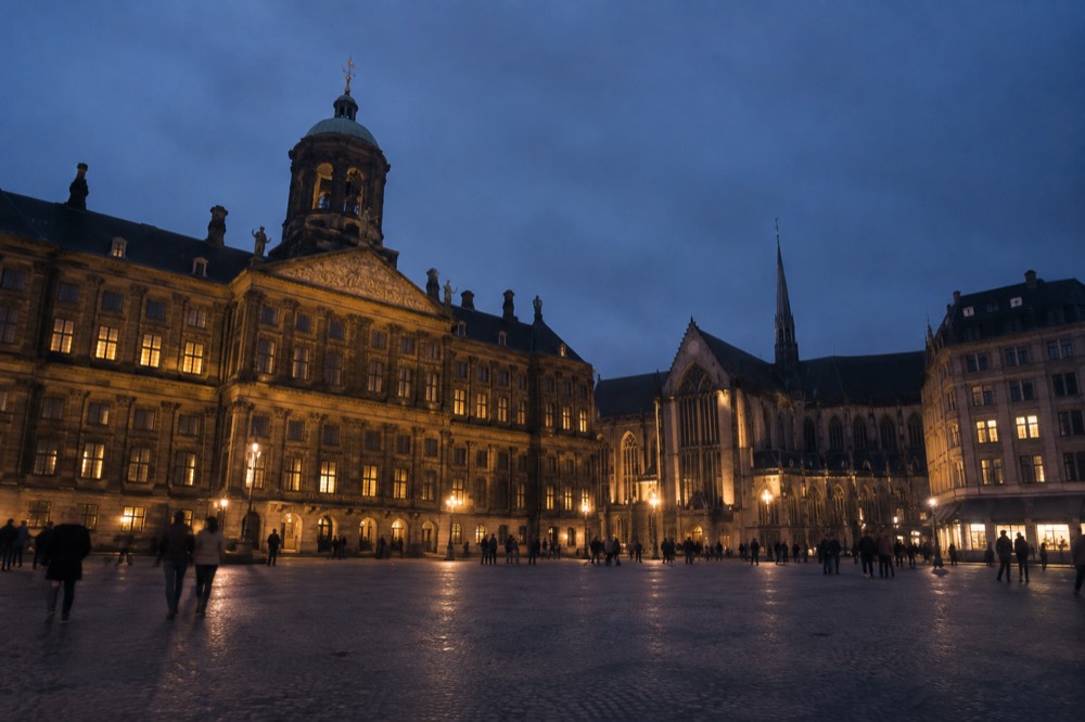 Brick facades and a quiet canal edge beside Dam Square