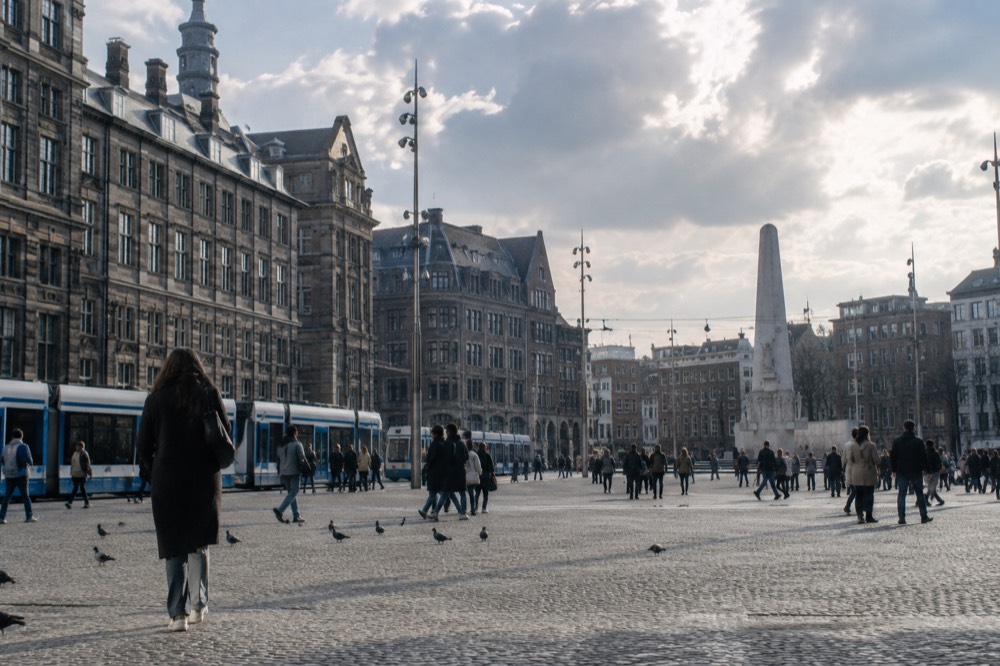 Dam Square seen from the Royal Palace steps, with the National Monument and passing trams
