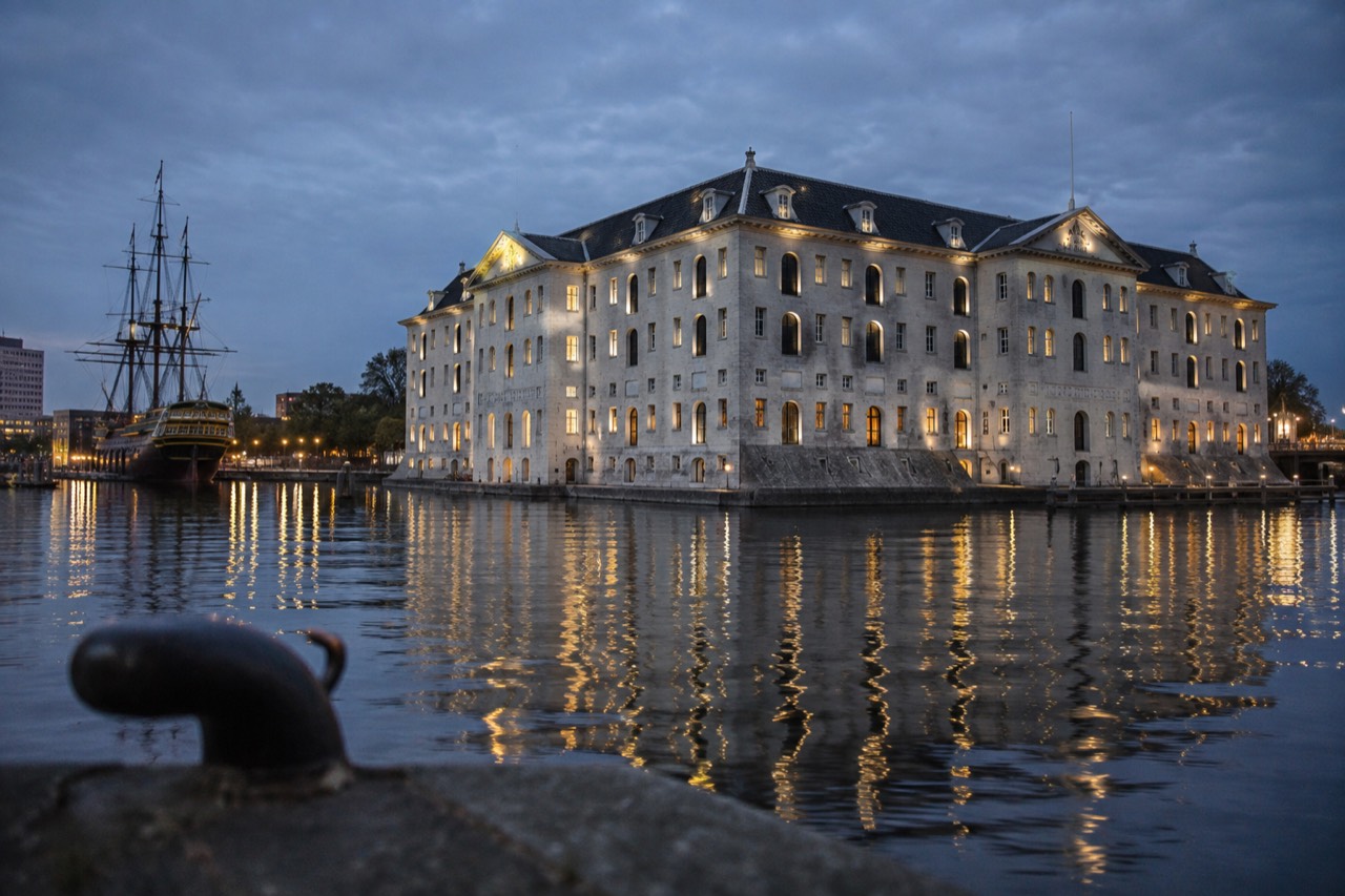 The 17th-century former naval storehouse of Het Scheepvaartmuseum reflected in the Oosterdok water