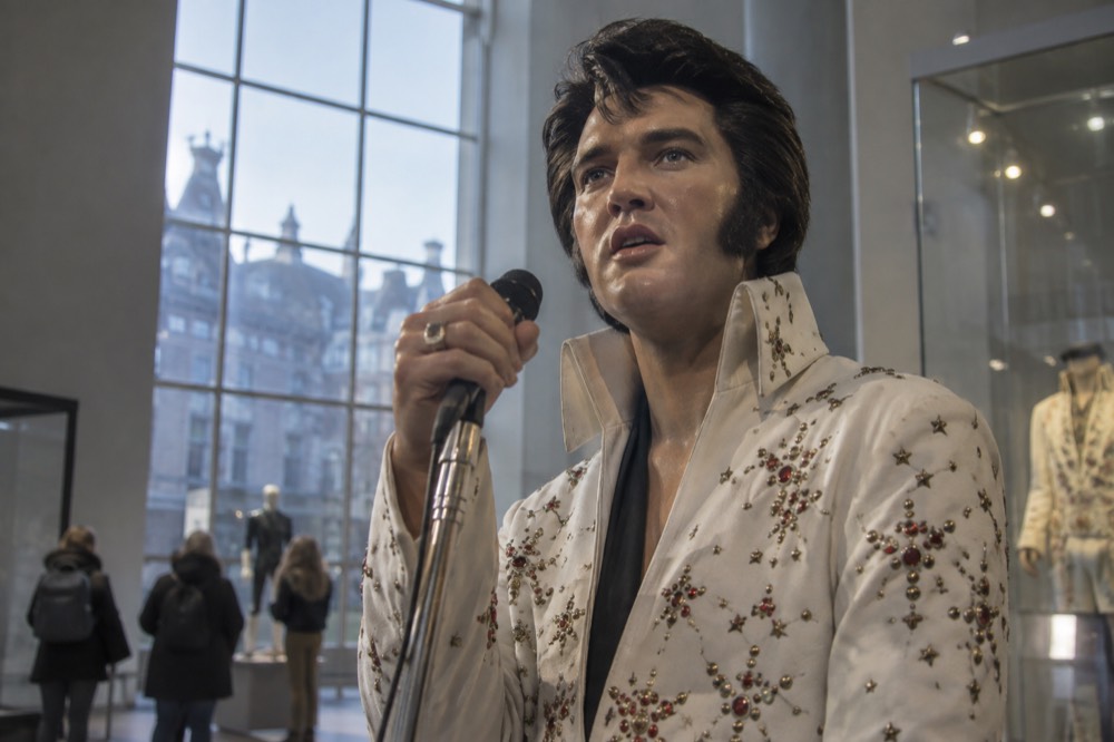 Wax figure of a famous singer displayed in a brightly lit museum gallery
