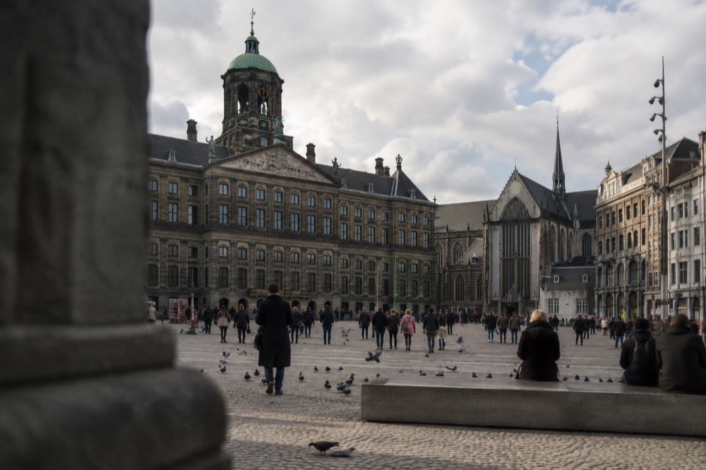 A quiet corner of Dam Square with trees overhanging the water