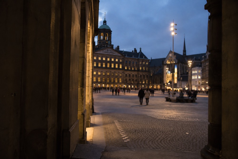 People walking past Dam Square, seen from across the street