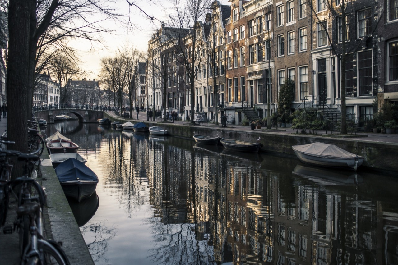 A 17th-century canal house facade on Herengracht in Amsterdam reflected in the canal water