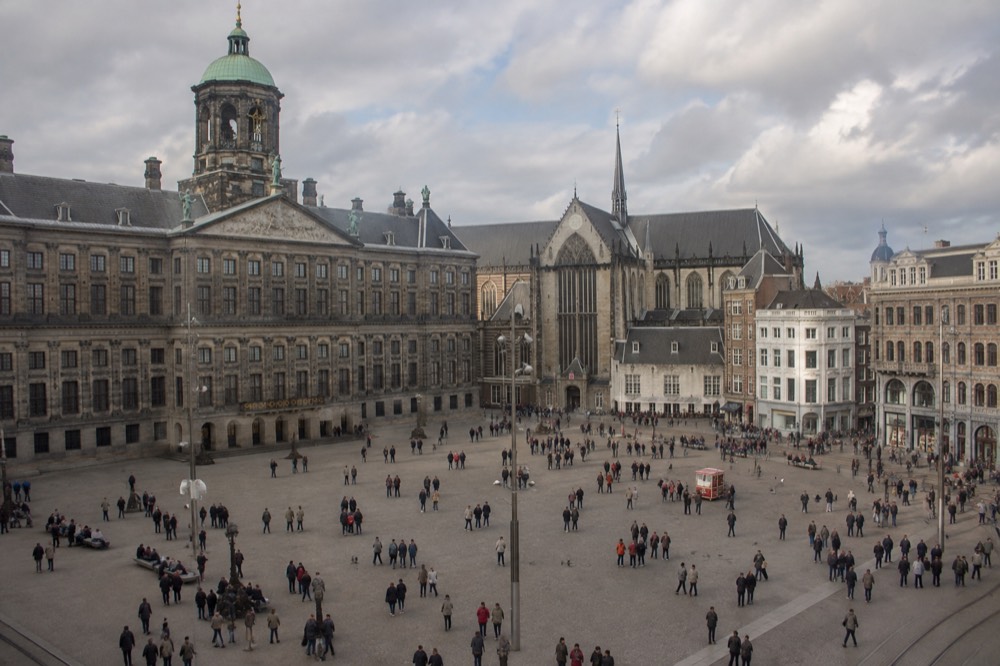 The waterfront near Dam Square under a broad grey northern sky