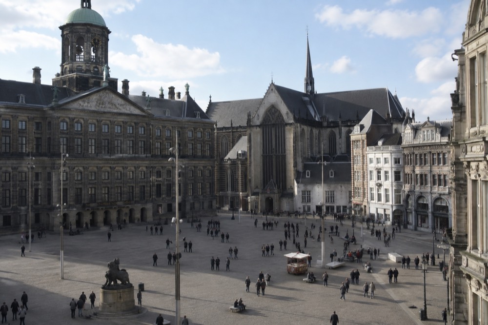 Brick facades and a quiet canal edge beside Dam Square