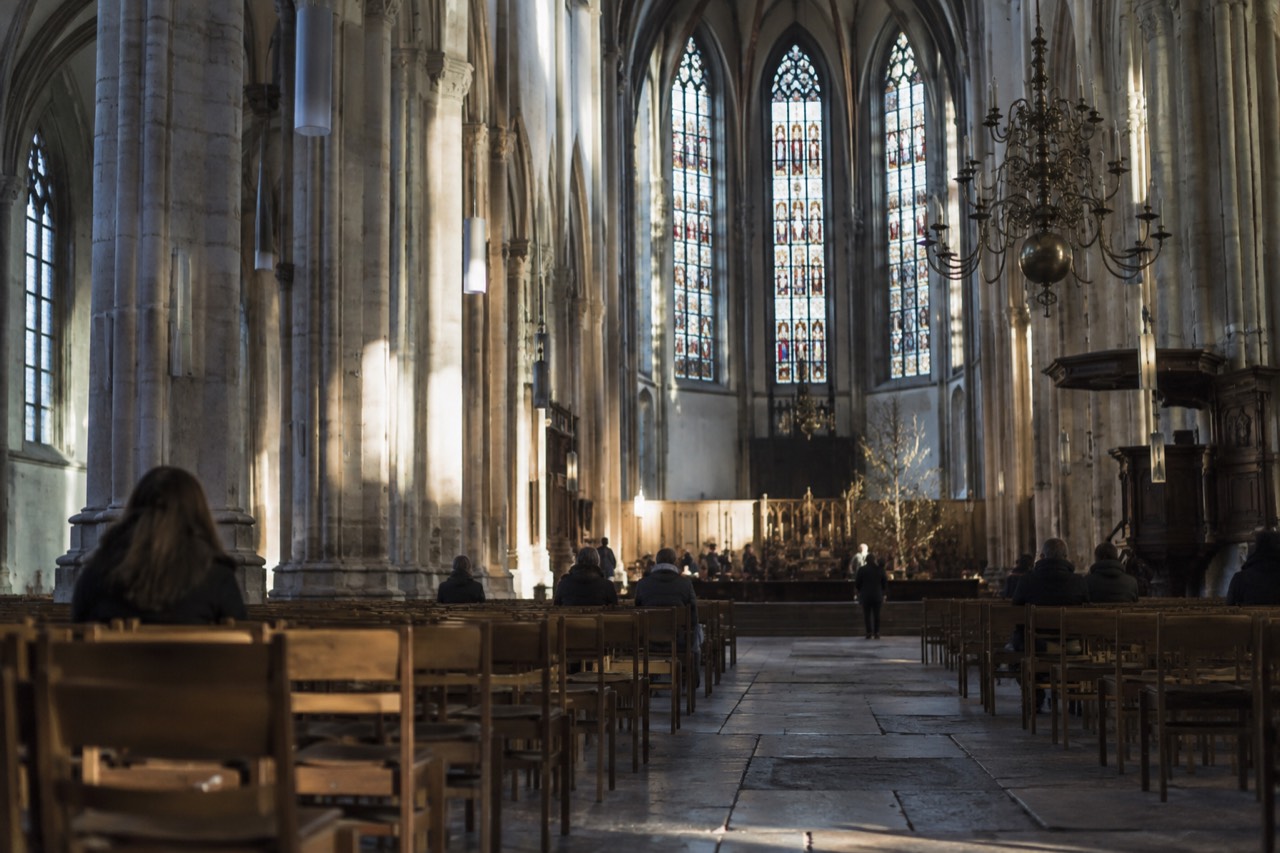 Gothic interior of the Nieuwe Kerk with tall stone columns and stained glass windows