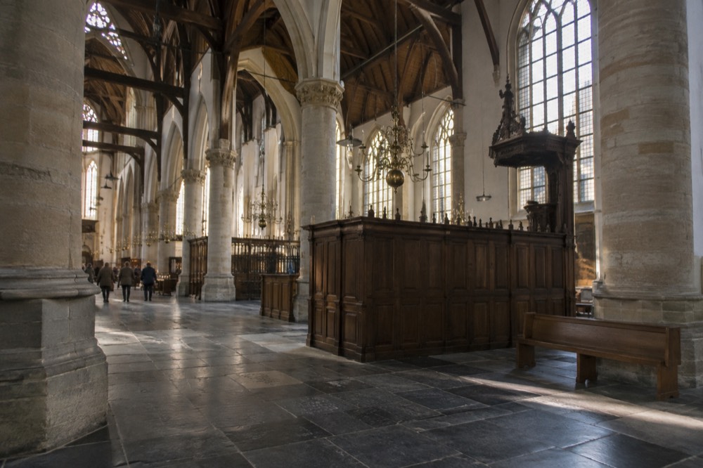 Interior of a Gothic church with a wooden vaulted ceiling and stone floor