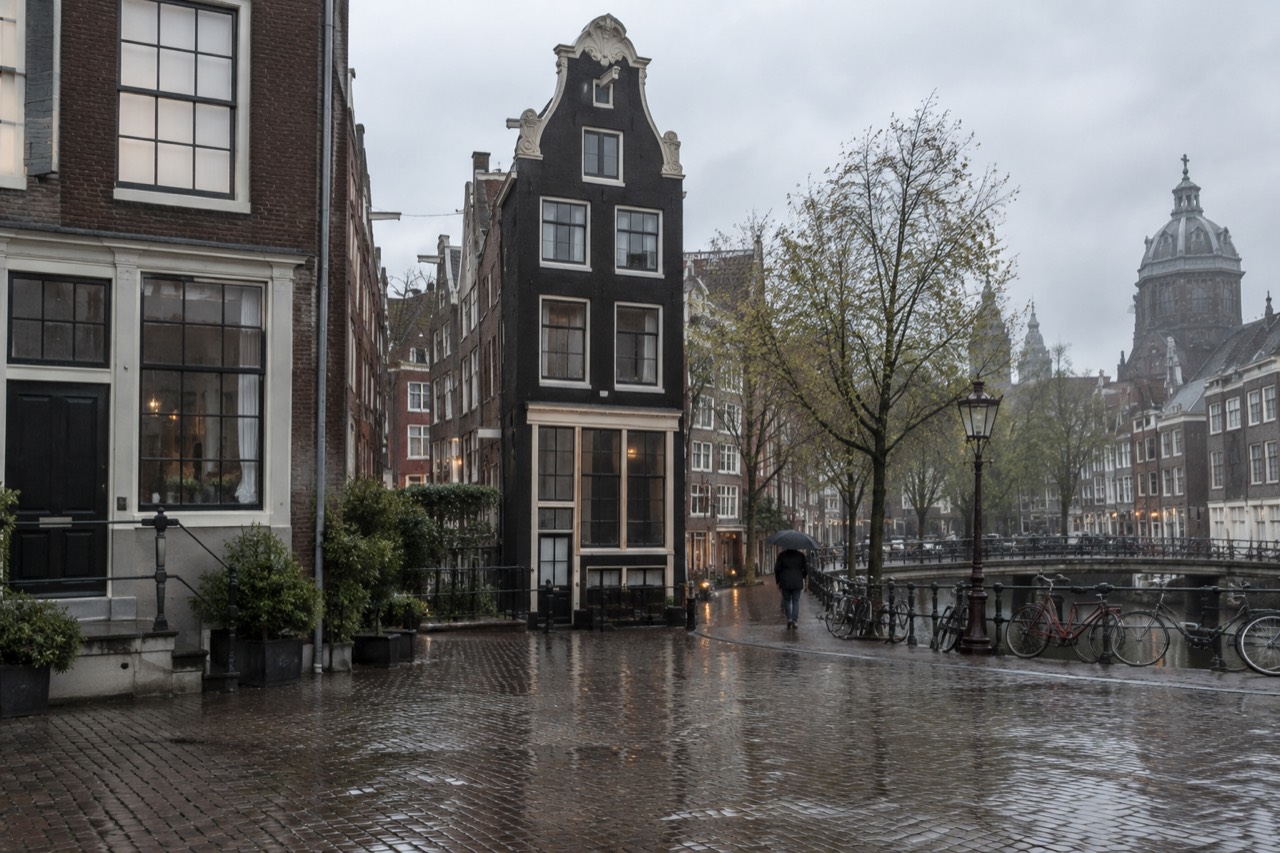A narrow seventeenth-century Amsterdam canal house facade seen from the street
