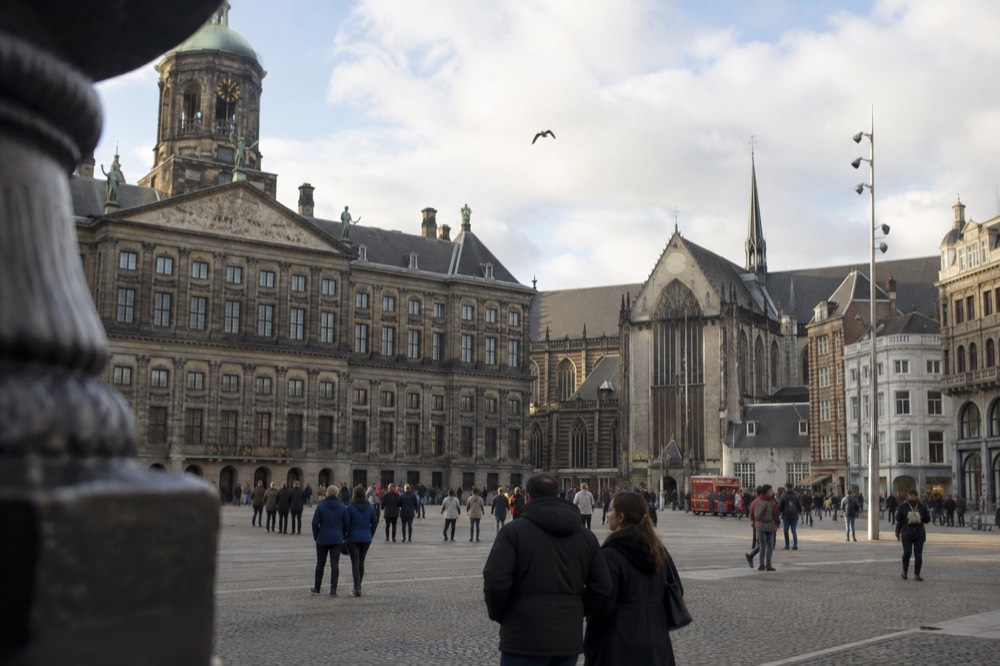The waterfront near Dam Square under a broad grey northern sky