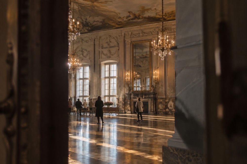 Ornate room with painted ceiling, tall windows and polished floor
