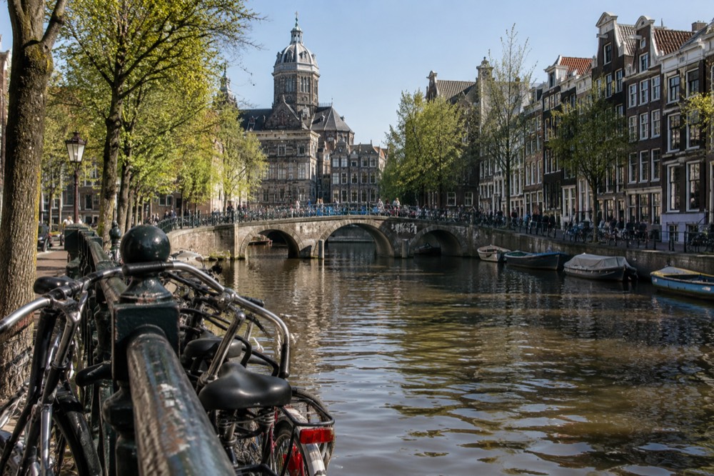 Canal view with bridge, trees and typical Amsterdam gabled houses