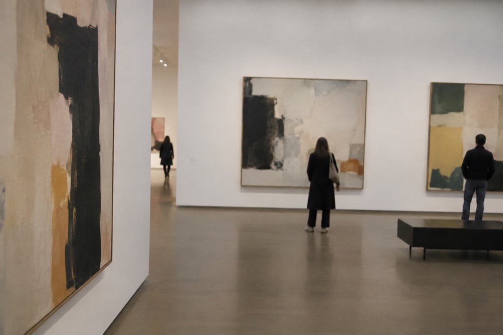 A bright modern gallery interior of the Stedelijk Museum with large abstract paintings on white walls