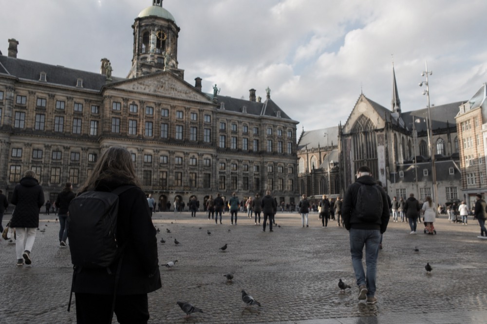 A quiet corner of Dam Square with trees overhanging the water