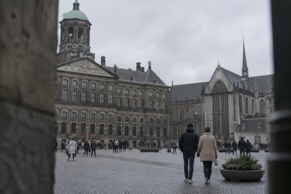 Brick facades and a quiet canal edge beside Dam Square