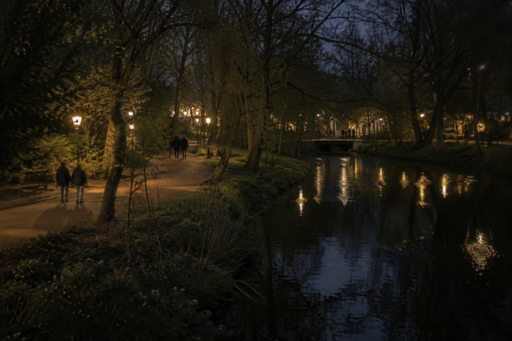 People walking past Vondelpark, seen from across the street