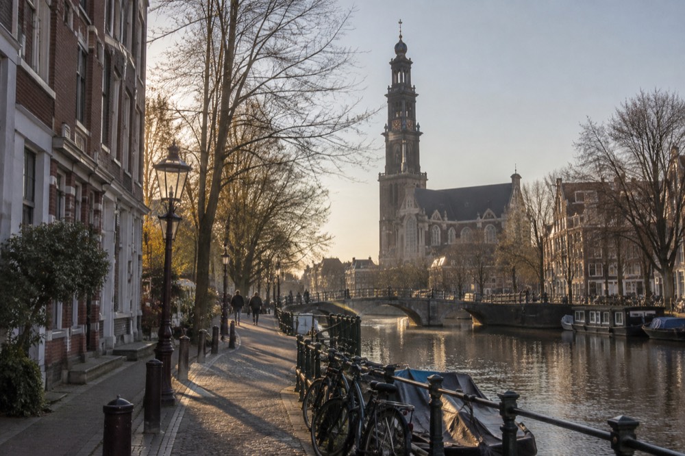 A canal bridge and moored boats close to Westerkerk