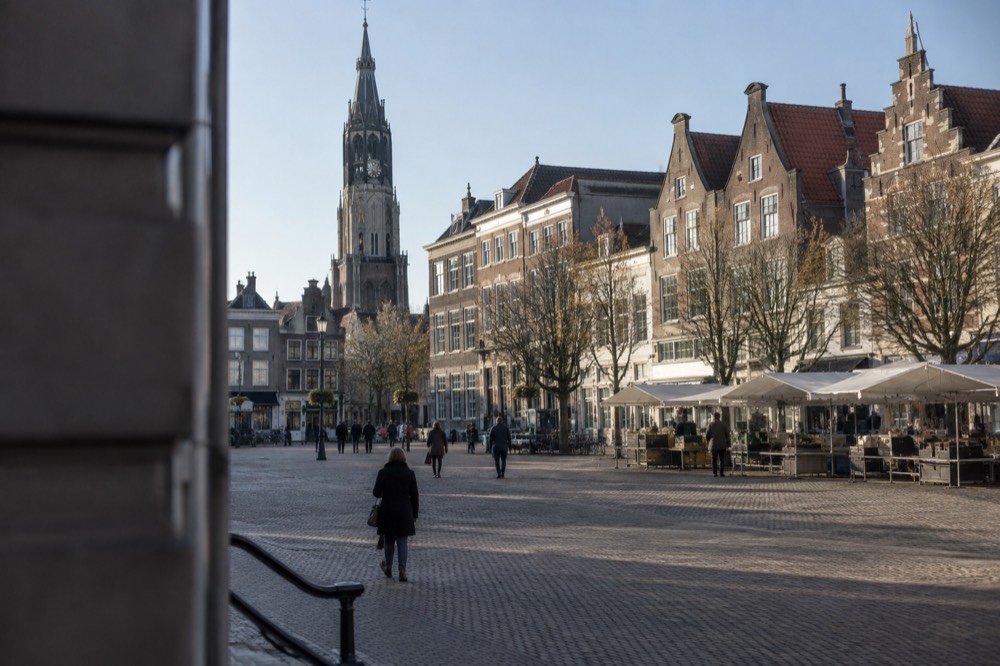 Delft market square with the Old Church tower and gabled facades on a clear day