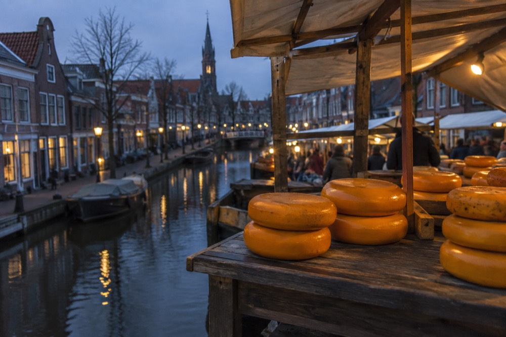 Cheese rounds stacked on a wooden market stall in Edam