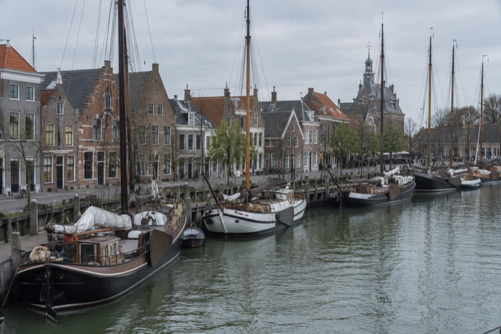Sailing ships moored at a harbour quay with historic Dutch townhouses behind them
