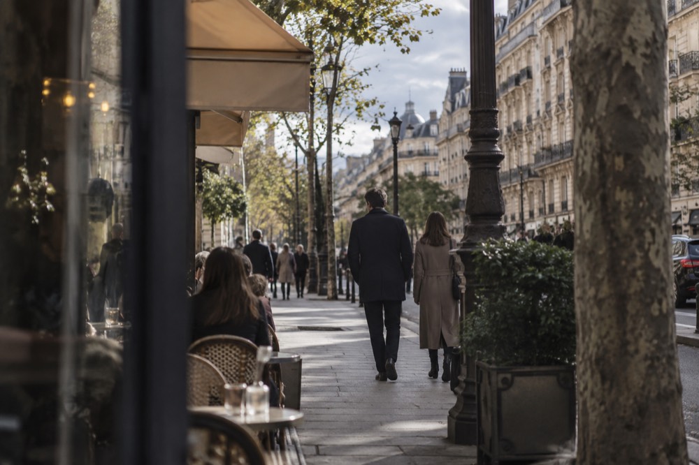 A Parisian boulevard with Haussmann-style stone buildings and cafe terraces