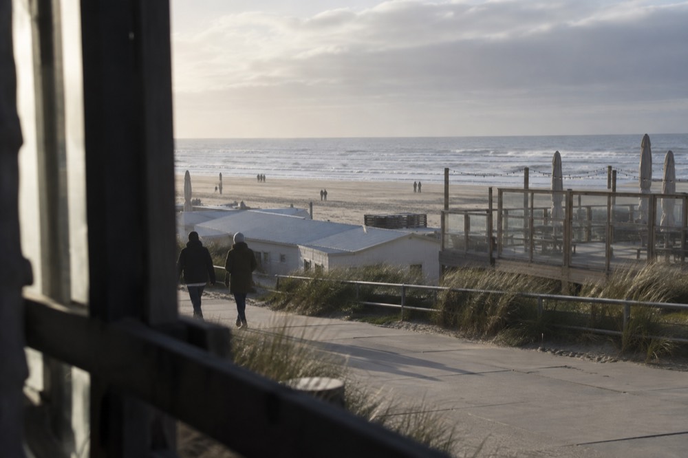 Zandvoort beach promenade with beach pavilions along the sand and a grey North Sea sky