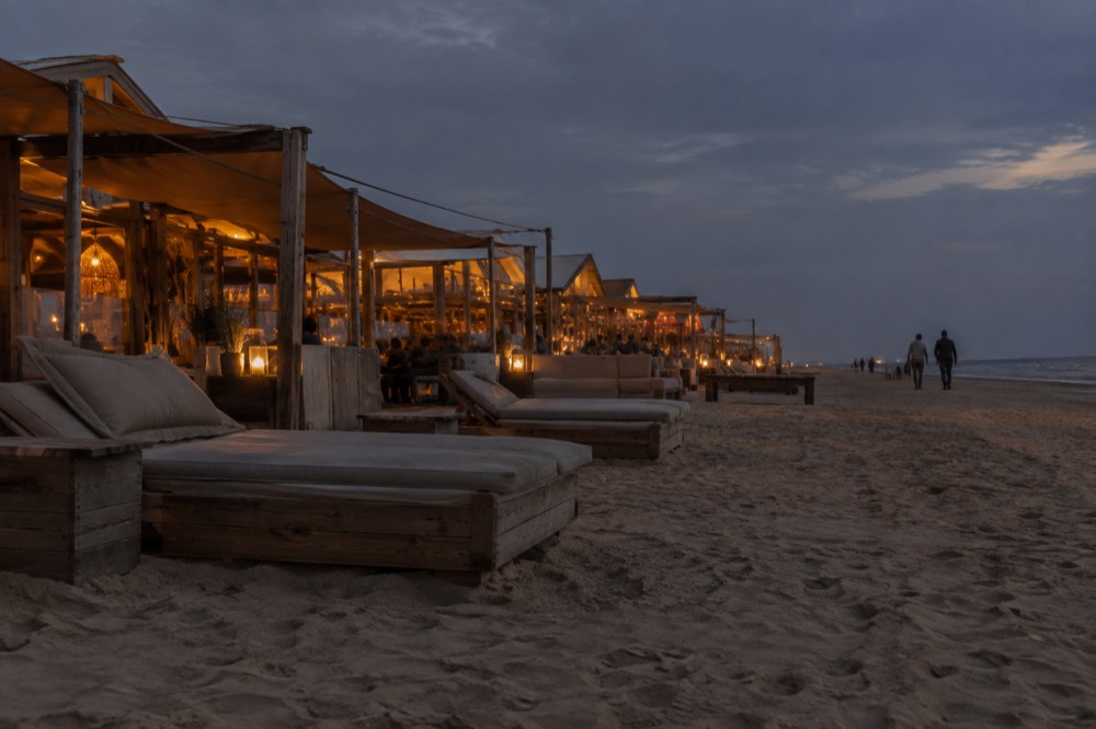 Rows of wooden beach pavilions on the sand at Zandvoort with loungers facing the sea